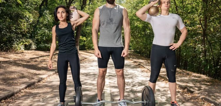 Three adults exercising outdoors with weights, promoting fitness and diversity.