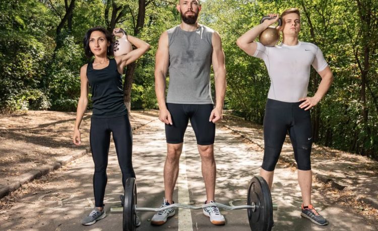 Three adults exercising outdoors with weights, promoting fitness and diversity.